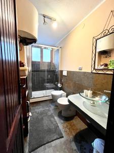 uma casa de banho com um WC, um lavatório e um chuveiro em STUPENDO 3 CAMERE, PISCINA, BOX, VICINISSIMO PISTE em Prato Nevoso
