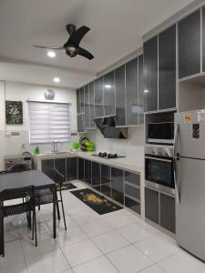 a kitchen with a refrigerator and a table in it at Homestay Greenway in Pasir Gudang