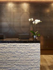a lobby with a table with a vase of flowers at Loews Chicago Hotel in Chicago