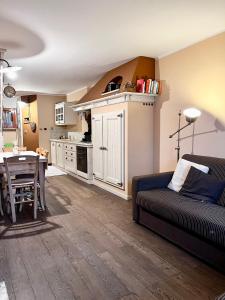 a living room with a couch and a table at STUPENDO 3 CAMERE, PISCINA, BOX, VICINISSIMO PISTE in Prato Nevoso