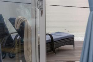 a sliding glass door with a chair and the ocean at Blue Yonder, Praa Sands in Praa Sands