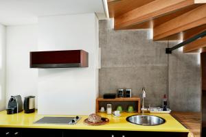 uma cozinha com um balcão amarelo e um lavatório em Wedina Serviced Apartments em Hamburgo