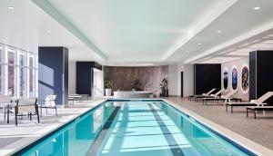 a pool in a hotel with chairs and a table at Loews Kansas City in Kansas City
