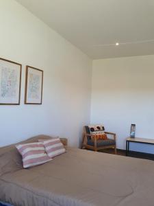 - une chambre avec un grand lit et une chaise dans l'établissement Casa en Laguna Soto Sur, à Corrientes