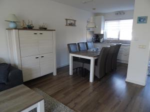 a kitchen with a table and chairs in a room at Kustverhuur, Vakantiepark Fort Soleil 23 in Breskens
