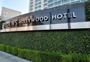 a sign for a hollywood hotel in front of a hedge at Loews Hollywood Hotel in Los Angeles