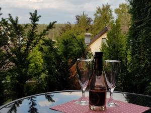 una botella de vino sentada en una mesa con dos copas en Ferienwohnung Morgensonne, en Schönwald