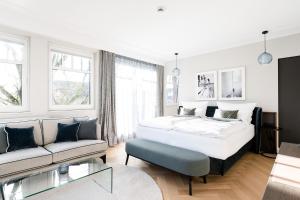 una camera da letto bianca con un letto e un divano di Clounys Hotel ad Amburgo