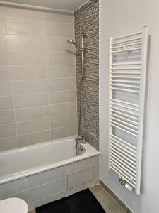La salle de bains blanche est pourvue d'une baignoire et de toilettes. dans l'établissement CAPRI - Sublime T2 Patte d'oie (Netflix, Terrasse), à Toulouse