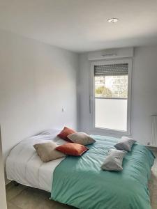 - un lit avec des oreillers dans une chambre avec une fenêtre dans l'établissement CAPRI - Sublime T2 Patte d'oie (Netflix, Terrasse), à Toulouse