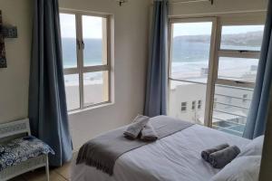 a bedroom with a bed and a large window at La Palma Villas No. 40 in Mossel Bay