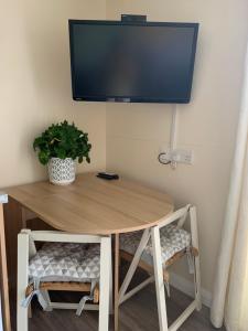 a wooden table with a tv on a wall at Pet friendly, disabled friendly cabin close to the humber and immingham in Goxhill