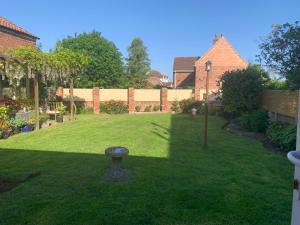 a garden with a birdbath in the middle of a yard at Pet friendly, disabled friendly cabin close to the humber and immingham in Goxhill