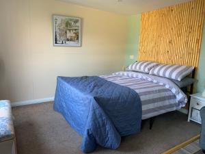 a bedroom with two beds and a picture on the wall at Pet friendly, disabled friendly cabin close to the humber and immingham in Goxhill