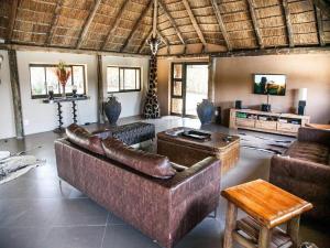 a large living room with a couch and a table at Sambane Game Lodge 