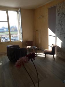 sala de estar con sofá, mesa y ventanas en Vaste appartement avec vue sur la Vienne, en Chinon