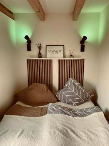 Schlafzimmer mit einem Bett mit einem Kopfteil aus Holz in der Unterkunft Holzhütte Ole zw. Meer & Wald mit Kamin & Sauna in Behrensdorf