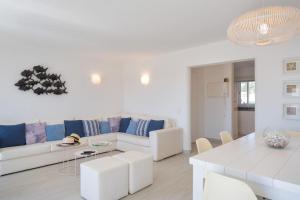 a white living room with a couch and a table at Beautiful apartment set in the heart of Quinta in Almancil