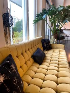 a yellow couch in a living room with pillows at Hôtel La Villa Cannes in Cannes