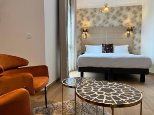 a bedroom with a bed and a couch and a table at Hôtel La Villa Cannes in Cannes