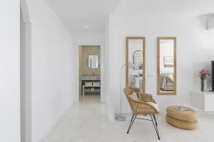 a white room with a chair and mirrors at Mirador de la Marina in La Herradura