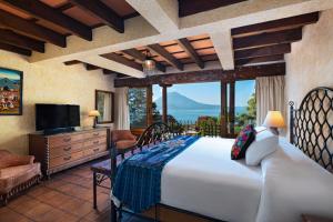 a bedroom with a large bed and a large window at Hotel Atitlan in Panajachel