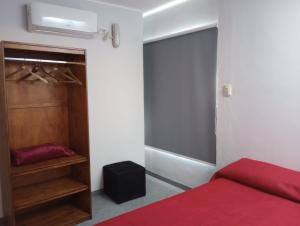 1 dormitorio con cama roja y armario en El Espacio en Junín