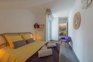 a bedroom with a large bed and a purple chair at Duingt-Entre Lac et Taillefer 2 pas piste cyclable et lac par LLA Selections by Location lac Annecy in Duingt