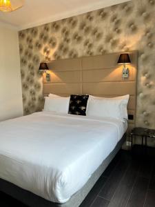 a bedroom with a large white bed with two lamps at Hôtel La Villa Cannes in Cannes