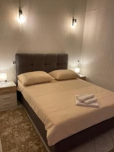 a bedroom with a large bed with two lamps on it at Apartmani Mariva in Dicmo