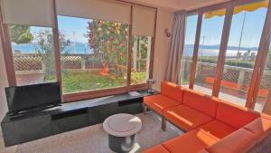 サント・マキシムにあるSplendid Azurのリビングルーム(オレンジ色のソファ、テレビ付)