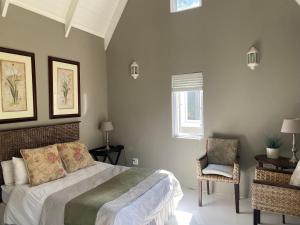 a bedroom with a bed and a chair and a window at The Stables on Drew Avenue in Howick