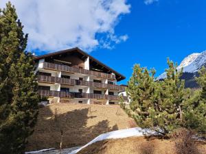 een hotel aan de zijkant van een heuvel met bomen bij Bella Val (272 Pe) in Lenzerheide