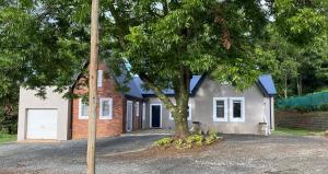 a house with a tree in front of it at The Stables on Drew Avenue in Howick