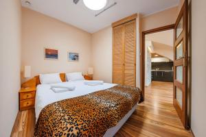 een slaapkamer met een bed met een luipaardprint deken bij Apartamenty Sun & Snow Willa Jazgór in Jastrzębia Góra