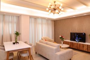 ein Wohnzimmer mit einem Sofa und einem TV in der Unterkunft JC SUITES in Manama