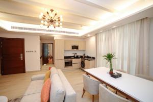 JC SUITES في المنامة: غرفة معيشة مع أريكة وطاولة طعام