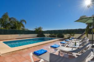a group of lounge chairs and a swimming pool at Monte Malva in Jávea