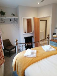 een slaapkamer met een bed met twee handdoeken erop bij Halt Cottage in Bridgnorth