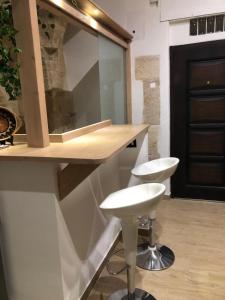 una cucina con due sgabelli e un bancone con bar di Casa Sipontina a Barletta