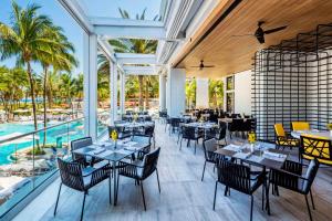 a restaurant with tables and chairs and a pool at Loews Miami Beach Hotel in Miami Beach