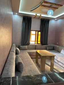 ein Wohnzimmer mit einem Sofa und einem Tisch in der Unterkunft Résidence AGDAL in Ad-Dakhla
