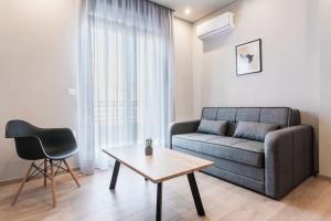 a living room with a couch and a table and a chair at Piraeus Deluxe 2BDR Apt - near metro and port in Piraeus