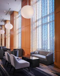a lobby with a couch and chairs and a window at Loews Chicago O'Hare Hotel in Rosemont