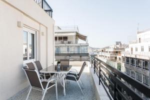 a patio with a table and chairs on a balcony at Piraeus Deluxe 2BDR Apt - near metro and port in Piraeus