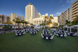 a group of tables and chairs in front of a building at Loews Miami Beach Hotel in Miami Beach
