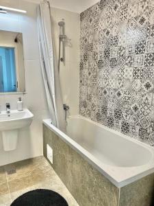 een badkamer met een bad en een wastafel bij Apartment Mara 2 in Timişoara