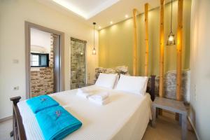 Villa Cretan View with Heated Swimming Pool في Pátima: غرفة نوم عليها سرير وفوط