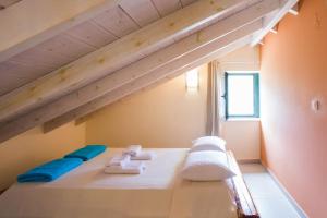 a white bed with blue pillows and towels on it at Villa Cretan View with Heated Swimming Pool in Pátima