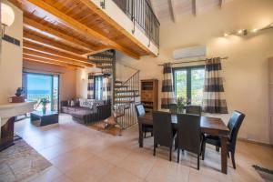 Villa Cretan View with Heated Swimming Pool في Pátima: غرفة معيشة مع طاولة وكراسي ودرج